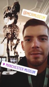 A selfie of Max with the T. Rex behind him at Manchester Museum.