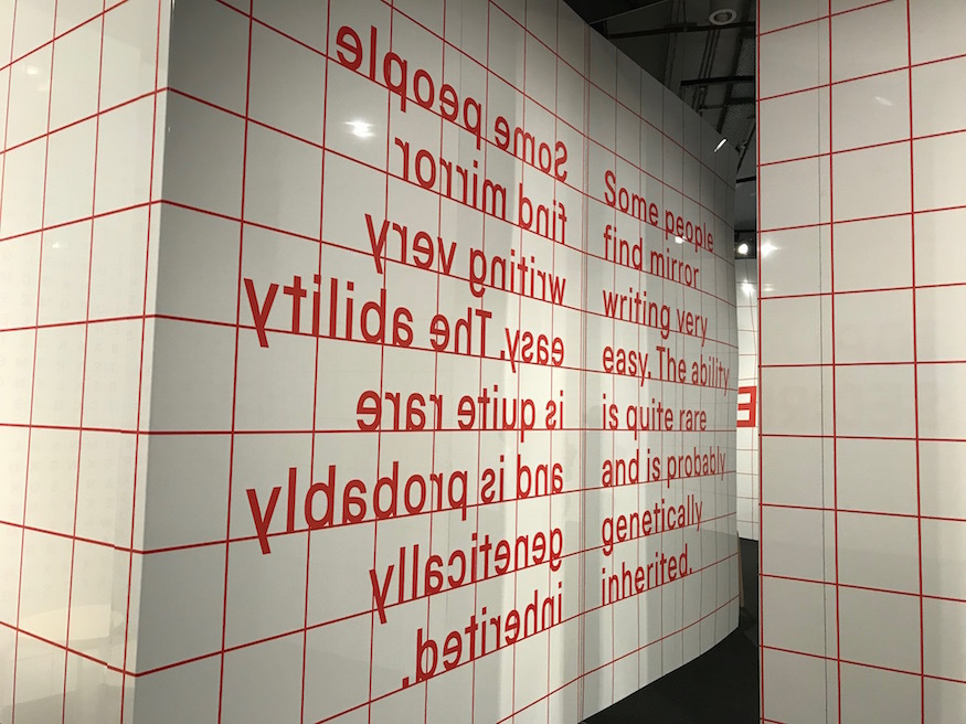 A reflective puzzle, in the mirror you can read "Some people find mirror writing very easy. The ability is quite rare and is probably genetically inherited.