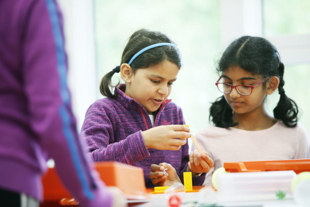 Girls involved in an engineering challenge workshop (“Topple, Bump and Roll”) at the Science Oxford Centre