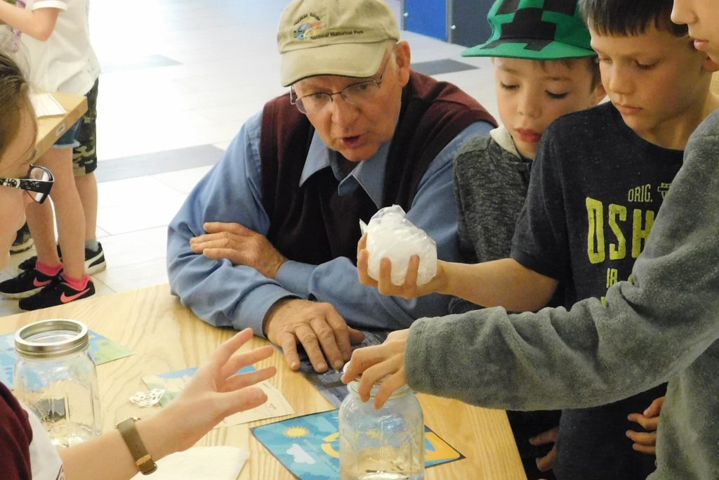 A mixed generation family trying out a water cycle experiment.